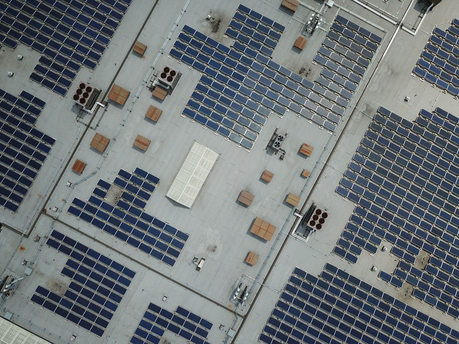 A rooftop solar array photographed from above, panels in even rows across a flat commercial roof.