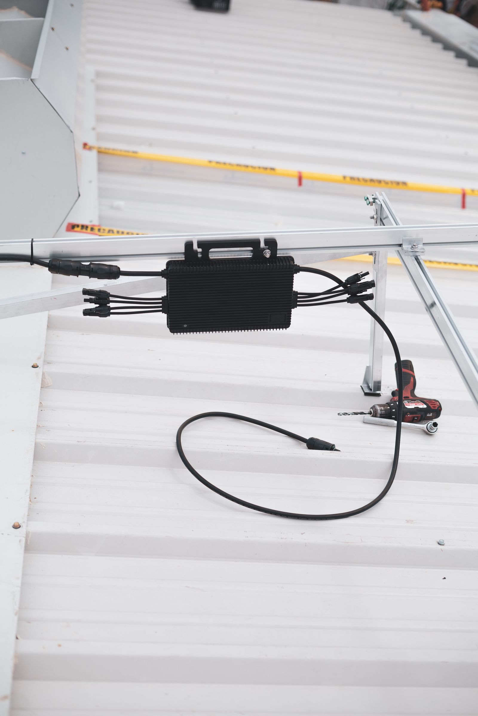 A solar charge controller and its cabling mounted on timber purlins inside a roof space.